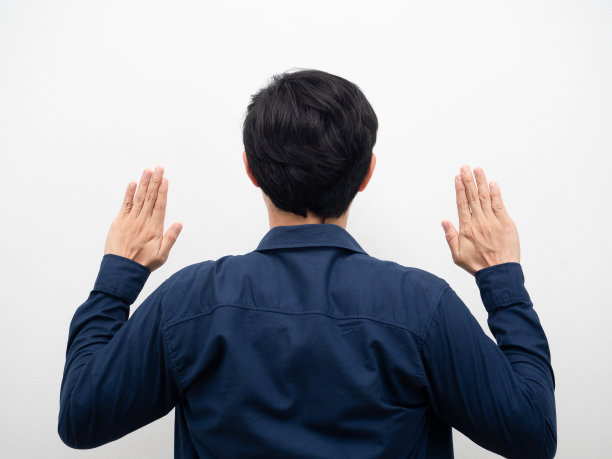 男人站起来，转过身来，举起双手，拍摄白色背景图片下载