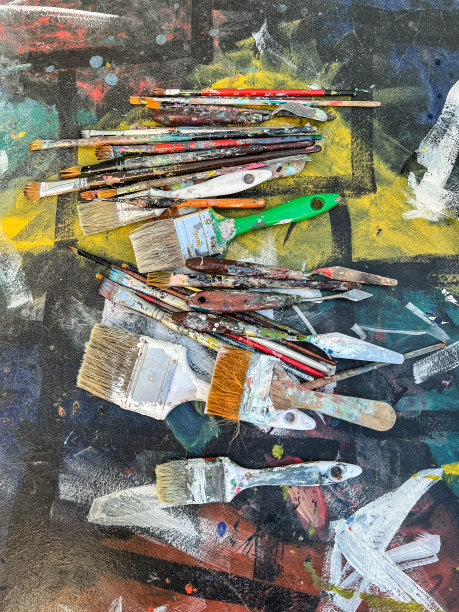 在艺术工作室或画廊里，画笔放在杂乱的彩色桌子上图片下载