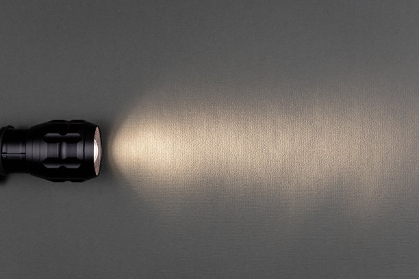 手电筒的一束亮光照在灰色的背景上图片下载
