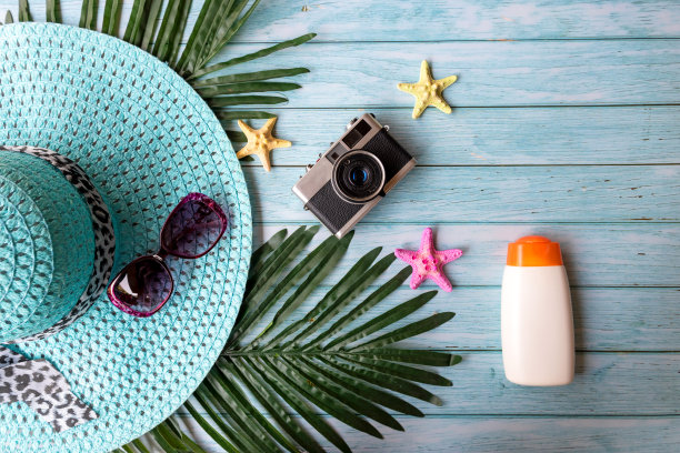 夏日时尚女人们戴着大帽子，涂上防晒霜，搭配一些配饰，带上老式相机去海滩旅行。图片下载