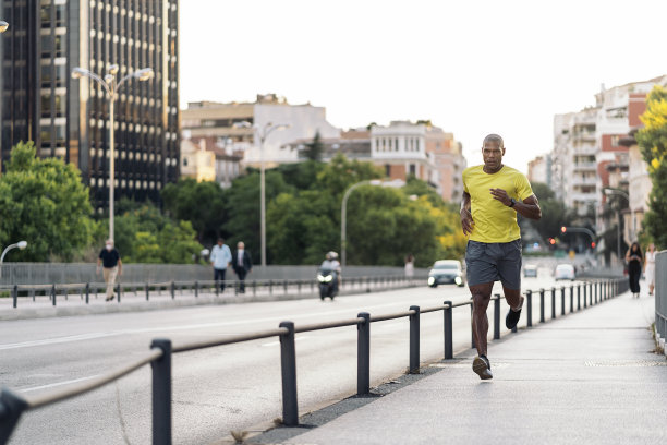 非裔美国运动员在城市户外人行道上慢跑图片下载