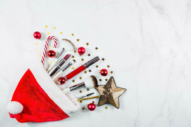 横幅。平面布局的组成与装饰化妆品产品和圣诞老人帽子在光的背景。冬季保健。美和时尚的概念。图片下载