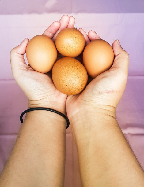 这是一张手拿着鸡蛋的照片。图片下载