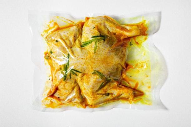 生腌鸡胴体与迷迭香真空包装在白色背景图片下载