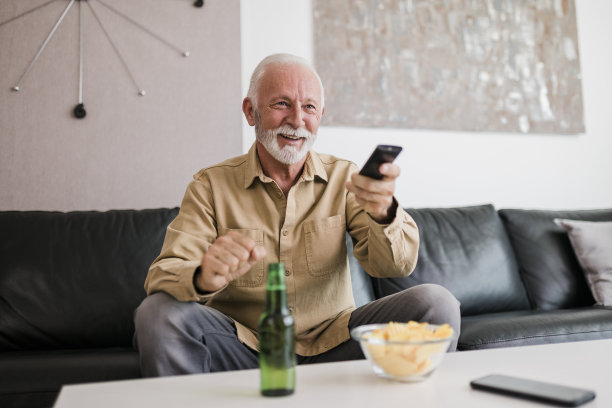 老人正在看电视上的体育比赛图片下载