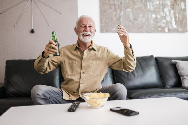 老人正在看电视上的体育比赛图片下载