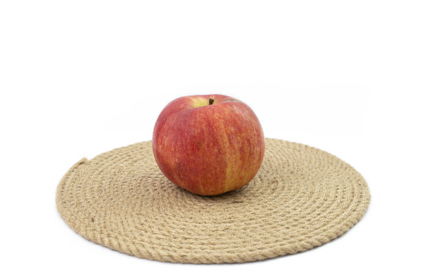 一个红苹果放在麻绳垫上图片下载