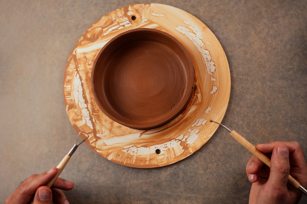 美丽的陶艺女主人用陶罐在主人的模具。女雕塑家学生用粘土在陶工的轮子上和桌子上的工具工作。灵感和创造力图片下载