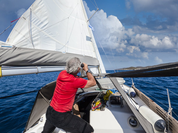 一名男子在自动驾驶船上观察周围的环境。图片下载
