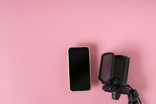 麦克风和智能手机在粉红色的背景上，有一个文本空间。图片下载