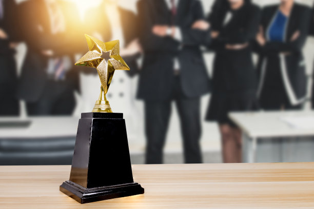 冠军的最佳和成就，胜者或胜利的概念，庆祝集团成功的商人庆祝成功的企业举行金奖在柔和的蓝色背景与bokeh图片下载