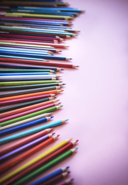 彩色铅笔排成一排，在柔和的粉色背景上留有文字的复制空间图片下载