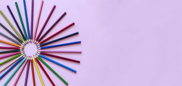 彩色铅笔在柔和的粉色背景上排成一圈，有很多的复制空间图片下载