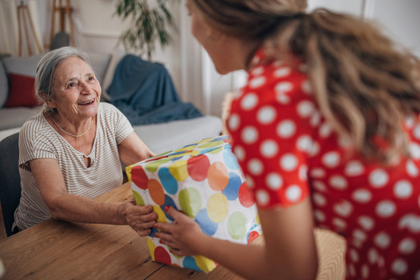 快乐的年轻女子给祖母送礼物图片下载