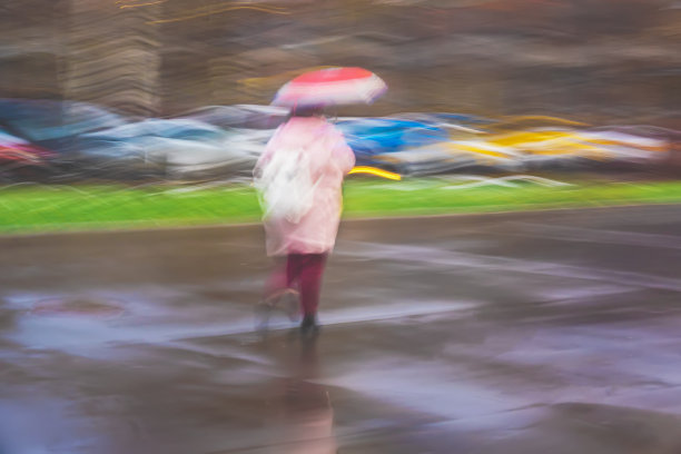 抽象背景匆忙模糊剪影女孩伞下，城市街道在雨夜图片下载