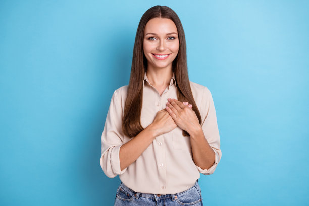 照片肖像的漂亮可爱的女士保持两臂手掌交叉在胸前穿时髦的衣服隔离在蓝色的背景图片下载