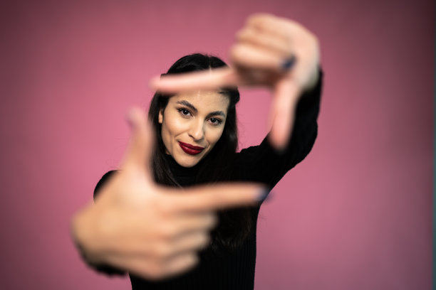 粉红色背景上一个年轻女子的肖像图片下载