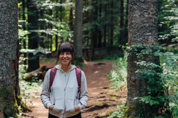 年轻的冒险女性的肖像徒步穿越山林图片下载