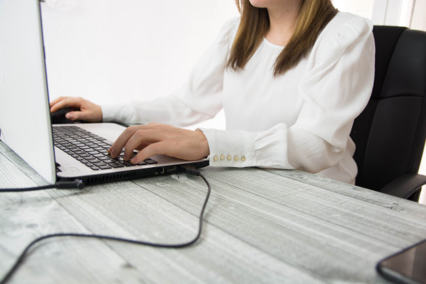 自信的商业女性在她的办公室在笔记本电脑上工作。- - -库存图片图片下载