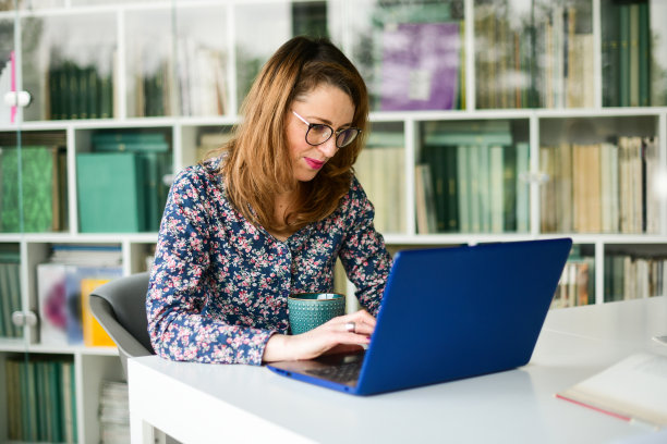 在图书馆用笔记本电脑工作的女商人图片下载