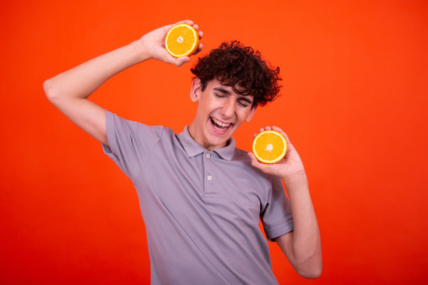 年轻有魅力的家伙和多汁的橘子。图片下载
