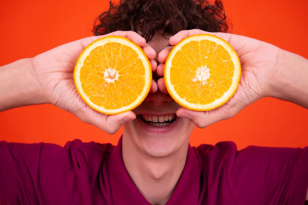 年轻有魅力的家伙和多汁的橘子。图片下载