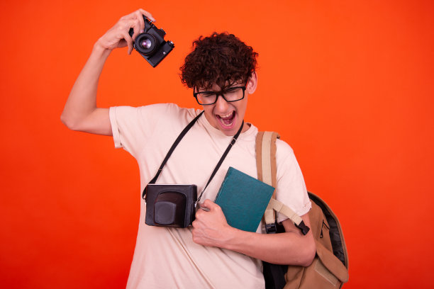 年轻迷人的背包游客。橙色背景。图片下载