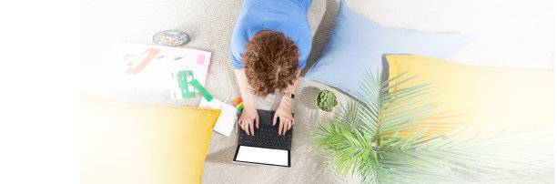 横幅创意工作在家里。女孩躺在公寓的地板上，手里拿着笔记本电脑。妇女在家庭办公室用笔记本电脑工作。从以上观点。在线学习、教育、购物和工作理念图片下载