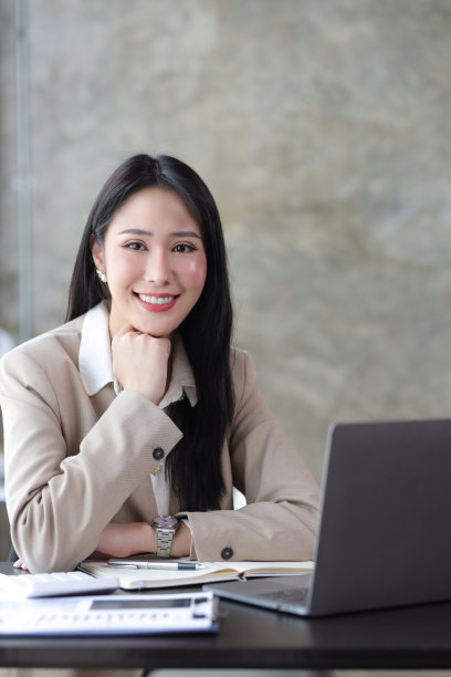 有吸引力的美丽的亚洲商业女性在办公室桌上的笔记本电脑上工作。图片下载