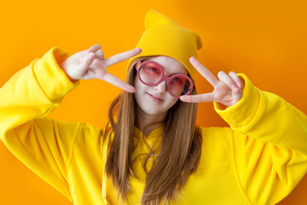 画像年轻漂亮的潮女人戴着黄色的帽子和眼镜。图片下载