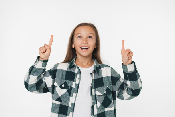 年轻惊讶的白人，青春期前的青少年，女学生，女儿，女孩指向显示拷贝空间向上孤立在白色背景图片下载