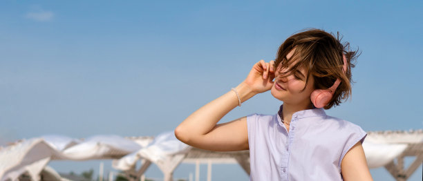 女孩在户外戴着耳机听音乐图片下载