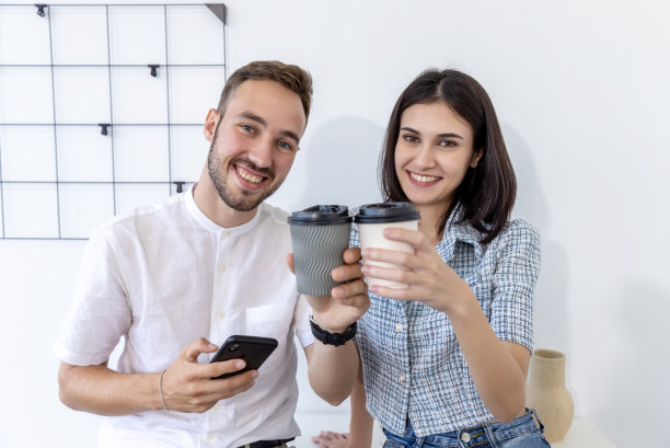 几个愉快的同事在办公室边喝咖啡边聊天。商人和女商人在喝咖啡图片下载