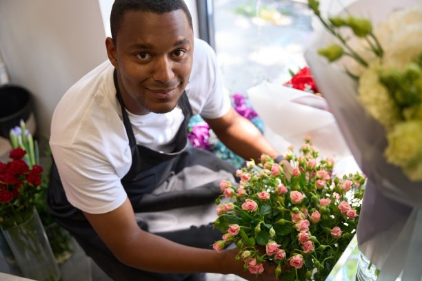非裔美国花商在窗边拿着花束图片下载