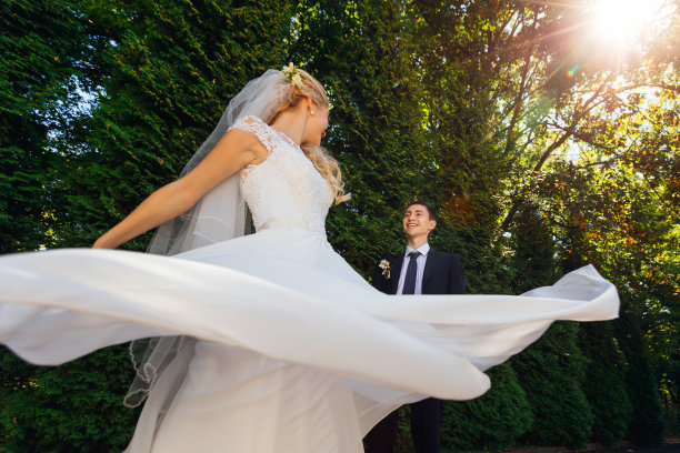 新郎看着他可爱的妻子，而她正在纺纱图片下载