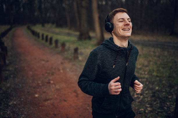 年轻的红发男子在森林里奔跑图片下载