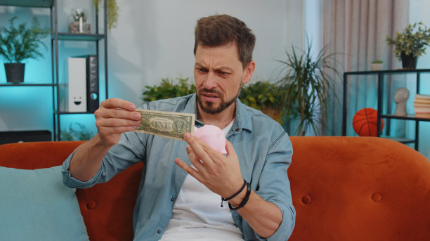 可怜的年轻人拿着储蓄罐和一元钞票，金融危机，破产，贫穷图片下载