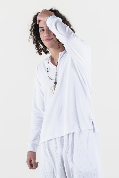 肖像的年轻男子穿着白色瑜伽服在白色背景，而看着相机。图片下载