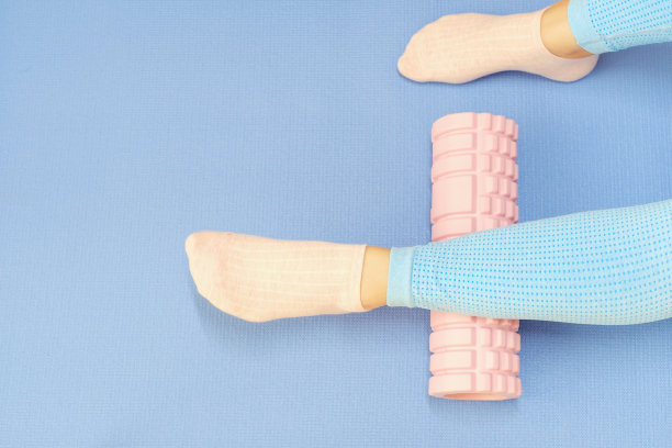 腿卷按摩泡沫辊特写蓝色背景，顶视图。图片下载