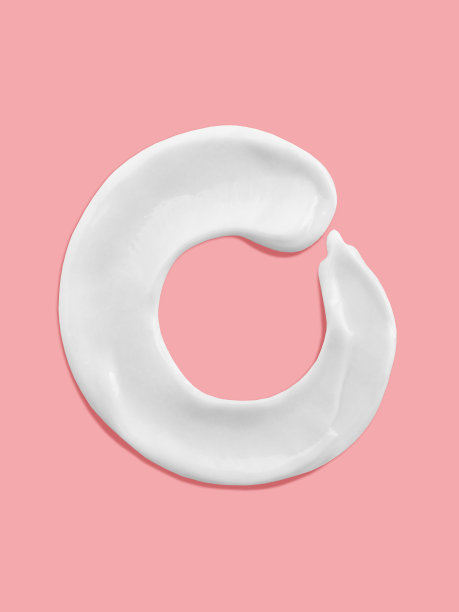 字母o，白色润肤霜涂抹笔画写在粉红色的背景，符号字母的一个字母图片下载