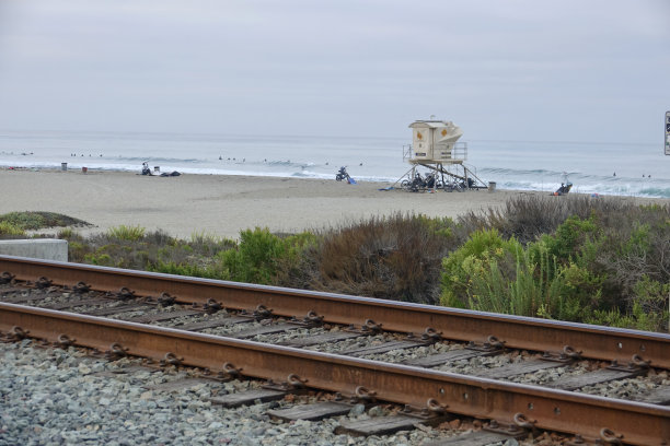 把海滩和山坡分开的铁轨图片下载