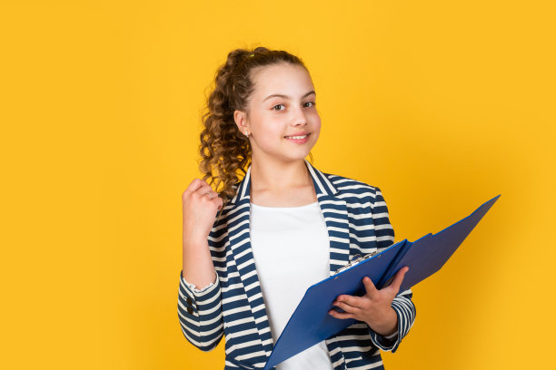 请在这里签名。小商人。快乐的童年。卷头发穿夹克的小孩。处理文件。女学生作业。回到学校。拿着办公室文件夹的小女孩图片下载