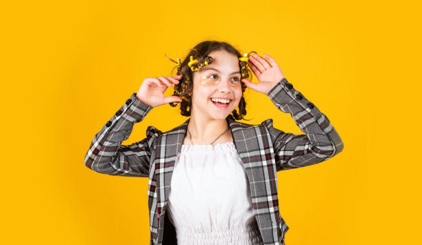 快乐的女孩在发夹玩发廊。为孩子做发型的简单提示。美发工具和发饰。脸上有补丁的孩子。用卷发器摆姿势。图片下载