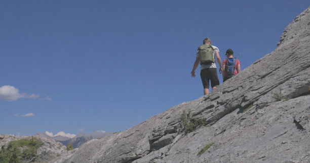 向导帮助小男孩爬上陡峭的岩壁图片下载