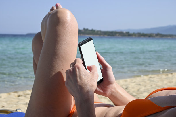 在沙滩上玩智能手机图片下载