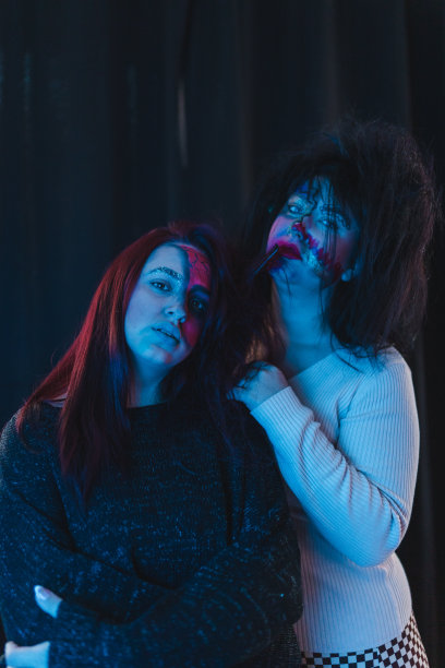 在蓝色灯光的照耀下，两个化妆的女人的肖像图片下载