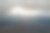 傍晚，从高空的飞机窗口鸟瞰远处的城市，上空覆盖着一层薄薄的雾霾和远处的云图片下载