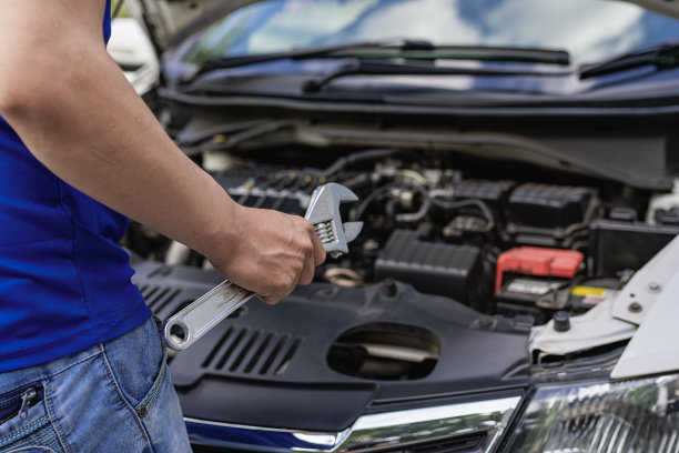 一个年轻人在离开前检查他的车是否需要修理。图片下载