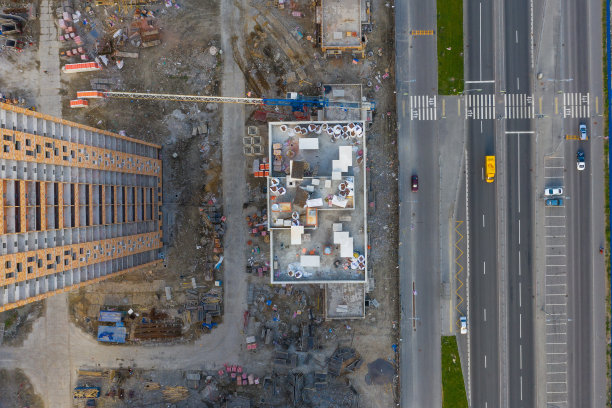 正在施工的高层住宅，街道上到处都是塔吊和建筑材料。从高空俯瞰。图片下载