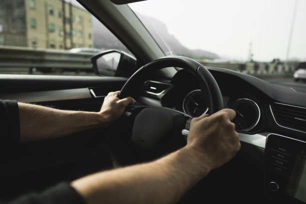 男性的手放在汽车方向盘上图片下载